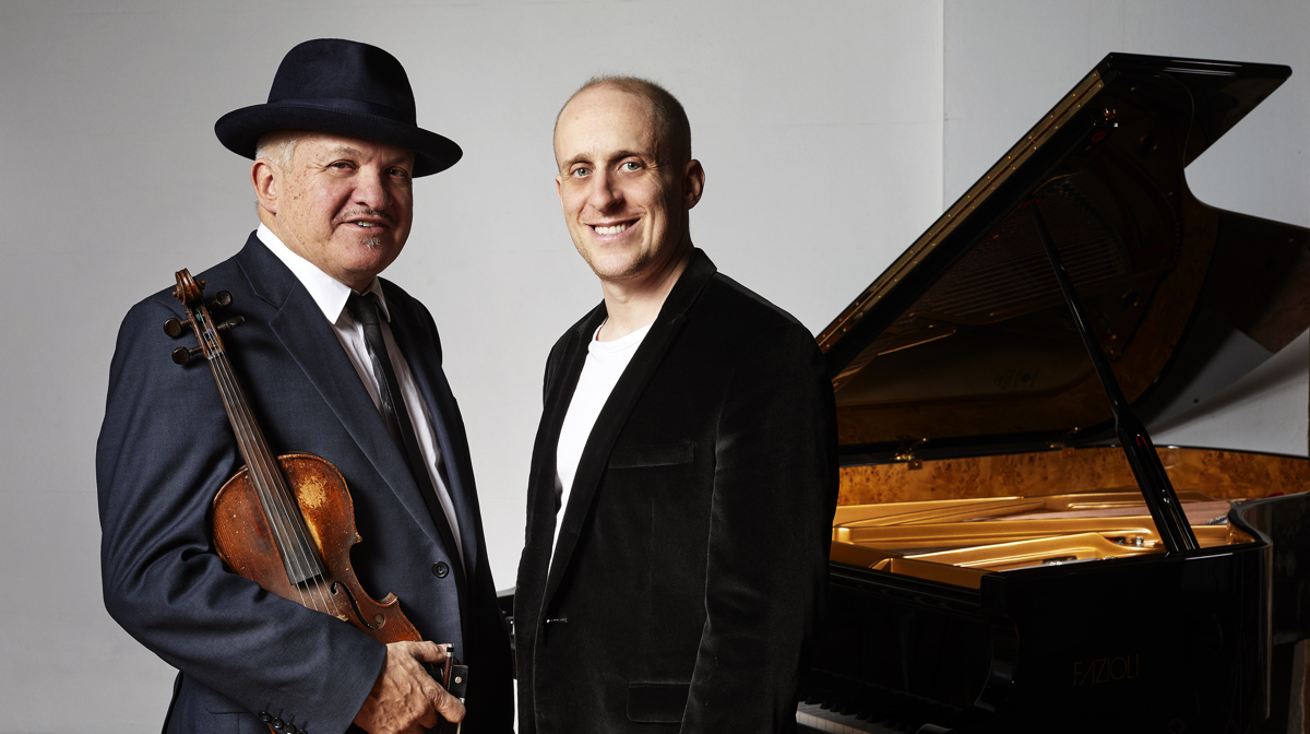 Simon Tedeschi & George Washingmachine standing next to a piano